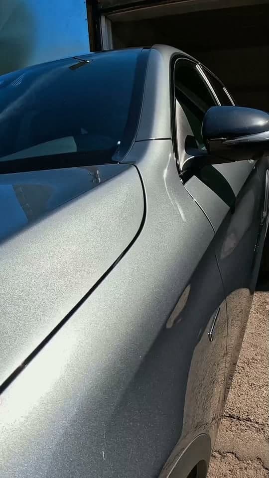Hõbedase auto läikiv uks garaaži ees